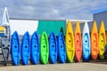 A row of colorful plastic kayaks