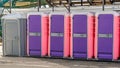 Row of colorful plastic portable restrooms