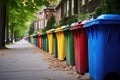 a row of colorful recycling bins lined up on a sidewalk