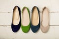 Row of colorful shoes ballerinas on a white wooden background. Royalty Free Stock Photo