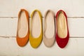 Row of colorful shoes ballerinas on a white wooden background. Royalty Free Stock Photo