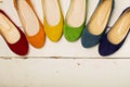 Row of colorful shoes ballerinas on a white wooden background. Royalty Free Stock Photo