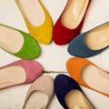 Row of colorful shoes ballerinas on a white wooden background. Royalty Free Stock Photo