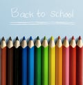 Row of colorful stationery of pencils for drawing on blue table with Back to School message