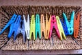 A row of colourful clothespins placed on a mat, used for hanging and dryiun laundry