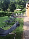 A row of comfortable lounge chairs stand in the garden in perspective on the grass as a place of rest Royalty Free Stock Photo