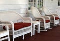 Row of comfy wicker chairs on rustic front porch