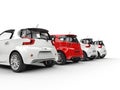 Row of compact cars - red stands out - back perspective view Royalty Free Stock Photo