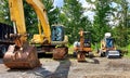 Row of construction vehicles lined up. Excavators and Roller