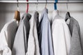 Row of cotton shirts and t-shirts hanging in the wardrobe. Royalty Free Stock Photo