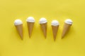 Row of creamy vanilla ice cream cones on yellow Royalty Free Stock Photo