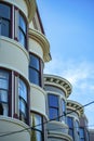 Row of cylindrical or circular houses with white stucco exterior and black window accent paint with power lines and blue