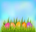 Row of decorated Easter eggs hiding in grass on sky background. Bottom border element. Royalty Free Stock Photo