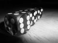 Row of dice on wooden table. Black and White Photo. Royalty Free Stock Photo