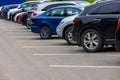 row of different color cars on asphalt parking lot at cloudy summer day Royalty Free Stock Photo