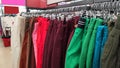 Row of different colorful pants trousers on hanger in shop, Royalty Free Stock Photo