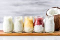 a row of different flavors of coconut yogurt in small glass jars