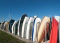 Row of dingy boats standing on end in boatrack