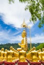 Row of disciple statues surrounding big buddha statue