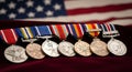 A row of distinguished military medals rests against the backdrop of the American flag. Royalty Free Stock Photo
