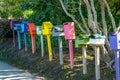 Row of diverse shapes and color letterboxes on street