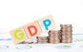 A row of dollar coins and wooden blocks with the English word GDP on the financial chart are climbing Royalty Free Stock Photo