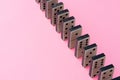 Row of domino tiles on pink studio background close up Royalty Free Stock Photo