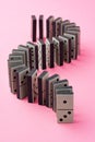 Row of domino tiles on pink studio background close up Royalty Free Stock Photo