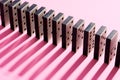 Row of domino tiles on pink studio background close up Royalty Free Stock Photo