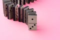 Row of domino tiles on pink studio background close up Royalty Free Stock Photo