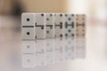 Row of dominos doubles in order fading into defocused background with reflection Royalty Free Stock Photo