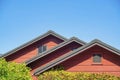 Row of double gable style roofs with red stucco exterior and dark accent paint around edges with visible insulation Royalty Free Stock Photo