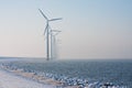 Row of Dutch windmills disappearing in winter haze