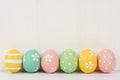 Row of Easter eggs over white wood Royalty Free Stock Photo