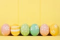 Row of Easter eggs over yellow wood Royalty Free Stock Photo