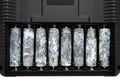 A row of eight unwrapped and heavily oxidized AA batteries inside the battery compartment of an electronic device