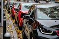 Row of electric cars at public charging station with plugged power cables Royalty Free Stock Photo