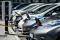 Row of electric cars at public charging station with plugged power cables Royalty Free Stock Photo