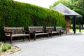 A row of empty benches in a public park. A place of rest, relaxation and meeting friends. The benches are made of wood