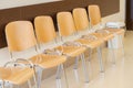 A row of empty chairs lined up against a wall in a clean and orderly waiting room, medical facility, corporate environment, Royalty Free Stock Photo