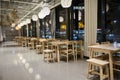 Row of empty chairs and tables of a restaurant in the Ikea furniture store in the evening