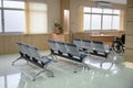 Row of empty chairs and wheelchair in waiting room at hospital Royalty Free Stock Photo