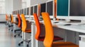 A row of empty computer workstations with colorful chairs in a modern office setting Royalty Free Stock Photo