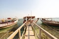 Row of empty old traditional dhow ships docked by the shore at Doha Port