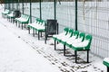 The row of empty plastic green seats at sports ground