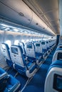A row of empty seats in an airplane with blue seats. Generative AI Royalty Free Stock Photo