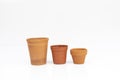 Row of empty terracotta plant pots in different sizes and shapes isolated on white background Royalty Free Stock Photo