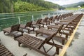 Row of empty wooden beach chairs near water Royalty Free Stock Photo