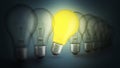 Row of extinguished light bulbs and one glowing yellow light bulb, creative idea. Individual approach and success, concept. Royalty Free Stock Photo