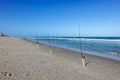 A row of fishing poles with lines cast into the Atlantic Ocean Royalty Free Stock Photo